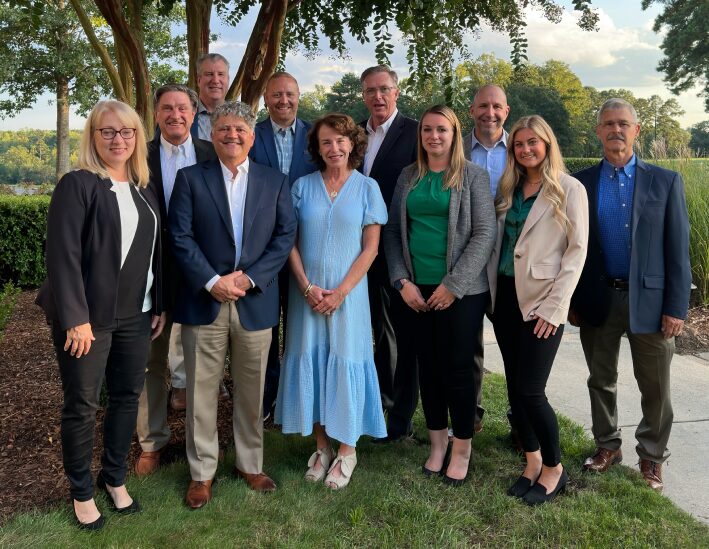 Transworld Business Advisors Team standing in a grassy park | Transworld Business Advisors